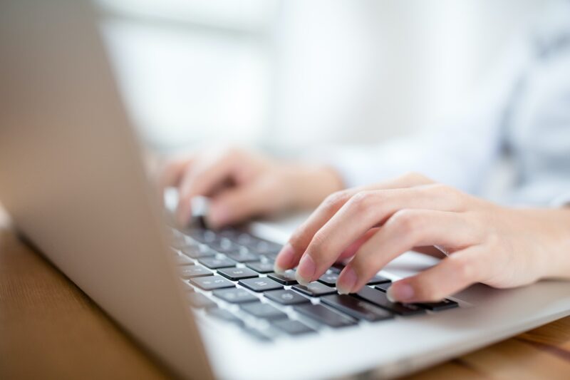 Woman hand typing on laptop keyboard